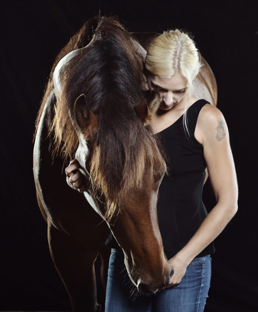 kobieta przytulająca się z koniem